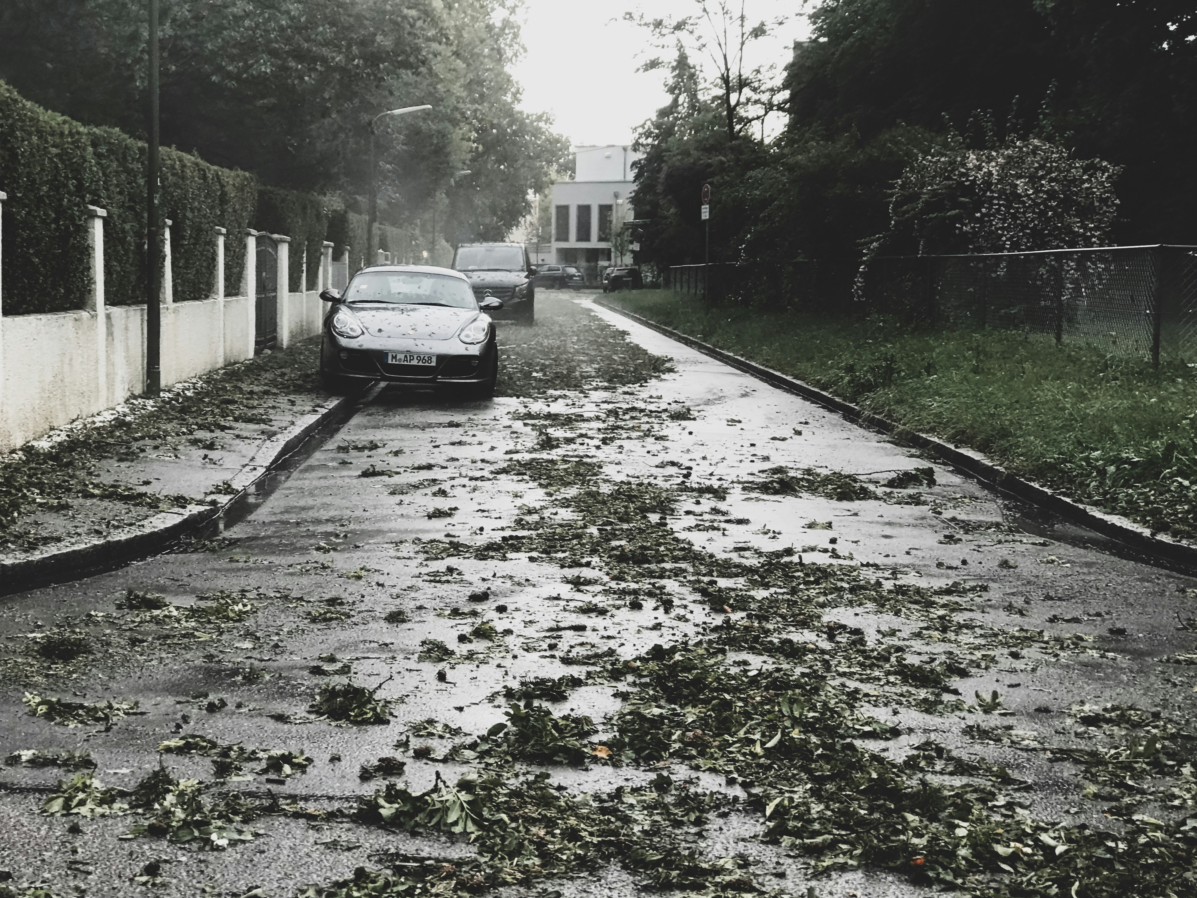 black vehicle parked beside white concrete wall
