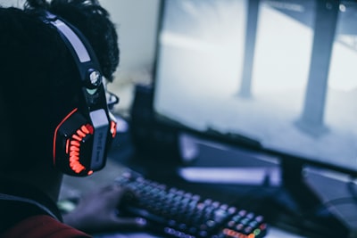 person wearing orange and black headphones gaming zoom background
