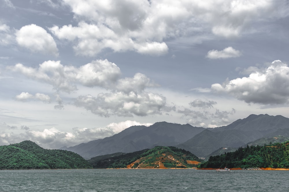 hills and mountains under cloudy sky