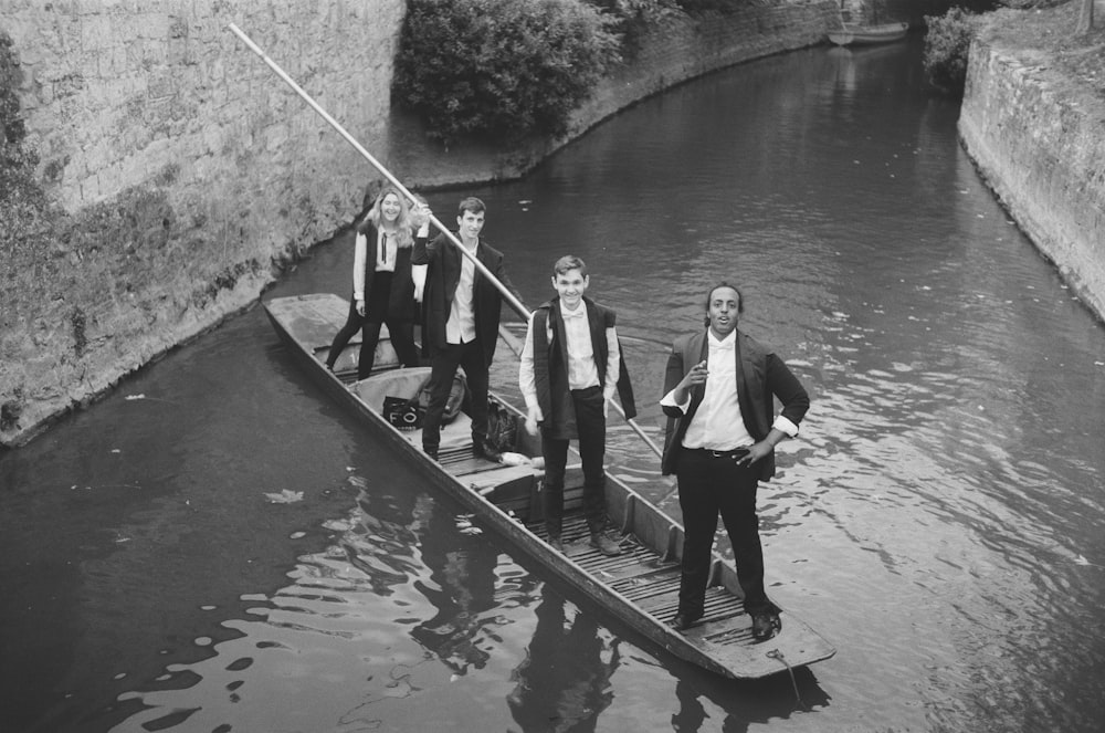 grayscale photography of people standing on boat