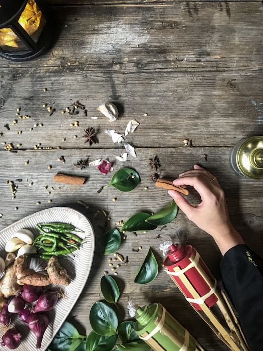 A rustic wooden table laid out with spices and herbs from the Silk Road era.