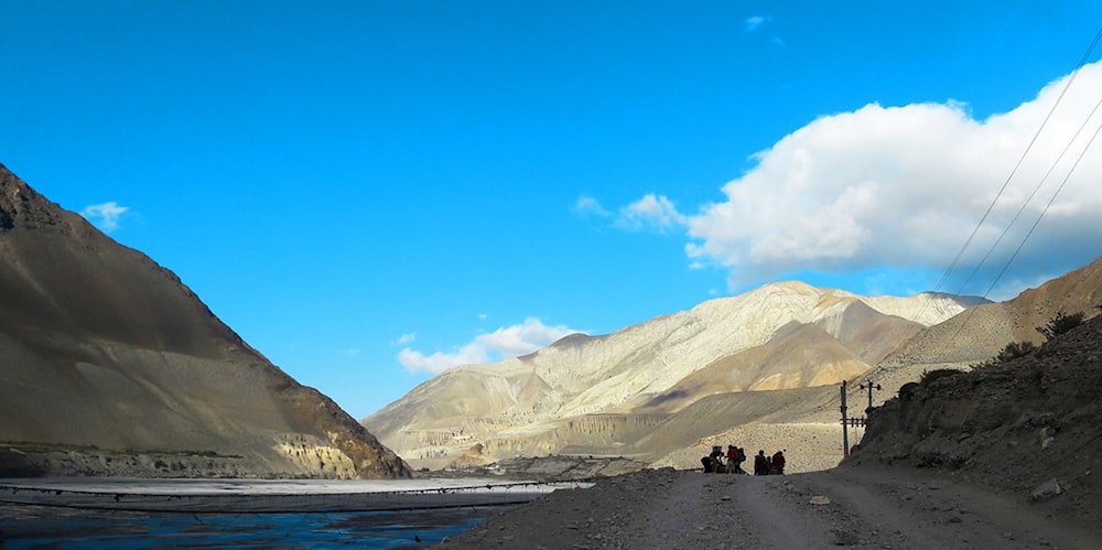 a group of people standing on the side of a road