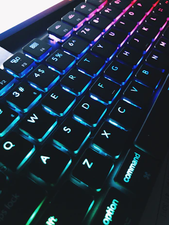 Close-up of hands typing on a sleek keyboard with a glowing blue-purple gradient background reflecting the brand colors.