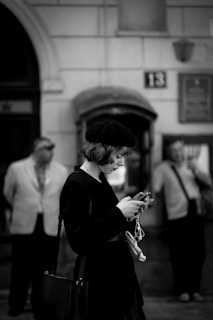 A professional woman using a smartphone in a modern urban setting.