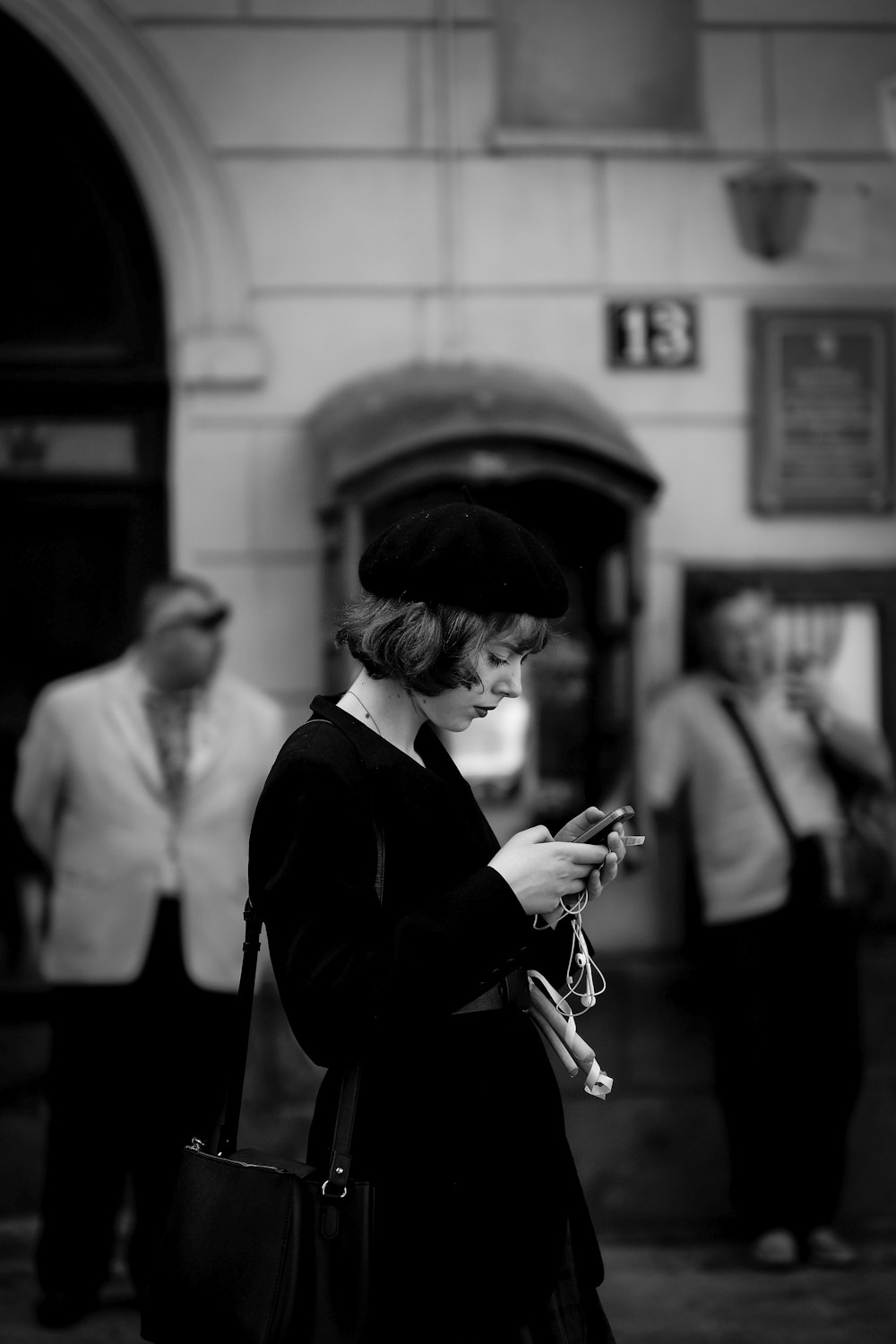 grayscale photo of woman using smartphone