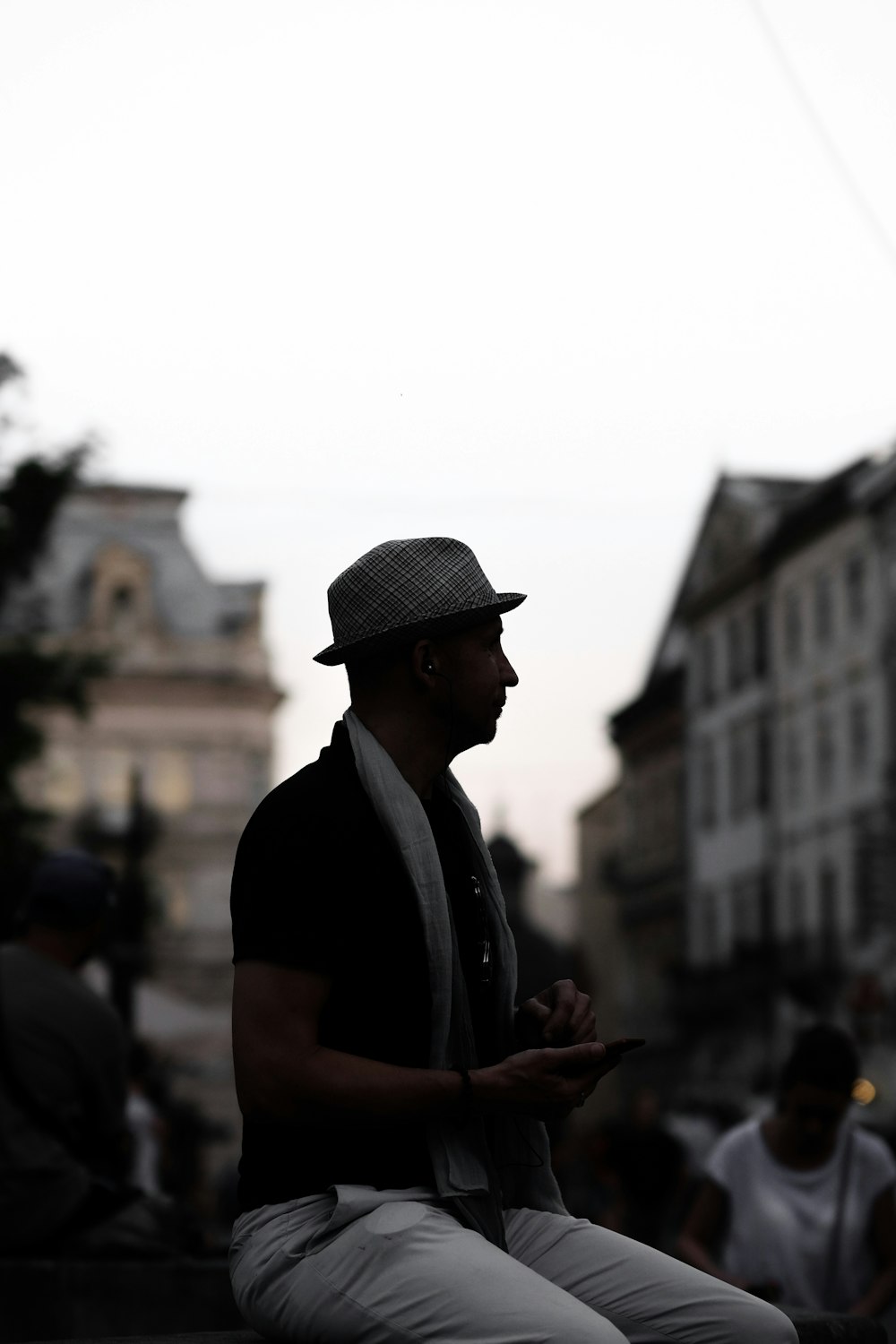 silhouette of sitting man next to person who wearing white shirt during daytime