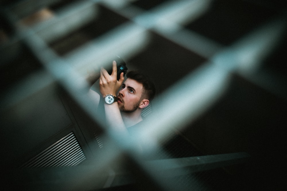 selective focus photo of man holding camera