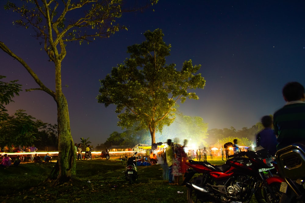 red motorcycle across people photo during nighttime