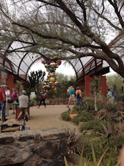 Visitors exploring outdoor garden art installations blending plants and creative sculptures.