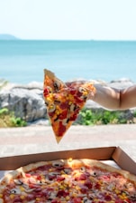 person holding slice of pizza