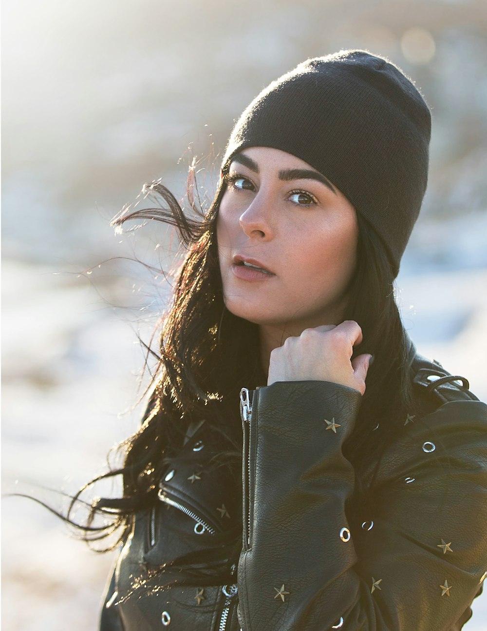 woman in white and black leather jacket with black knit cap
