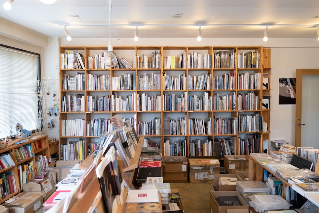 assorted books on brown wooden bookcase in library,