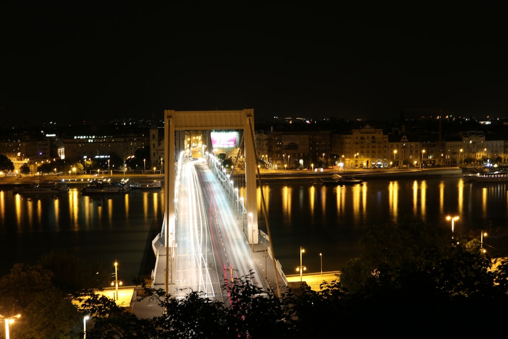 lighted city skyline across bridge