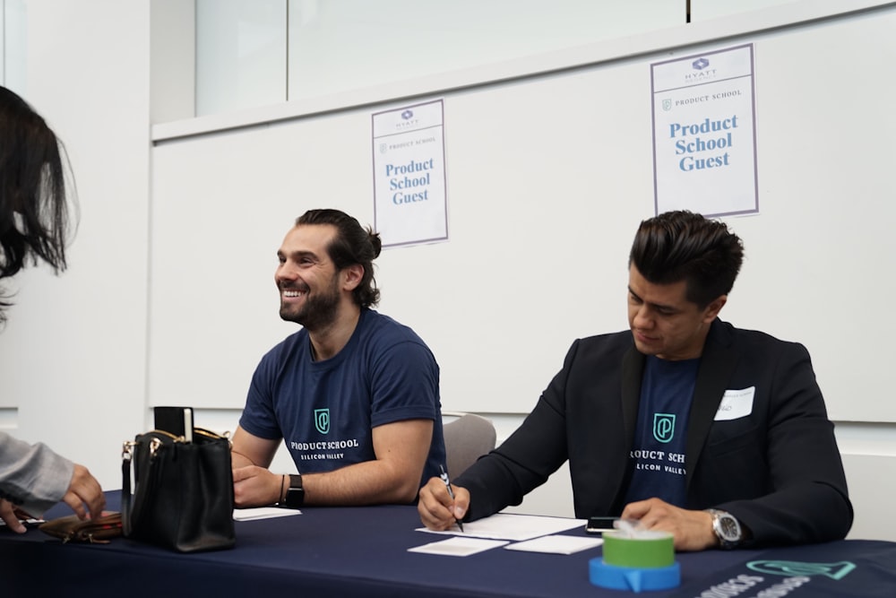 two men sitting on blue tables