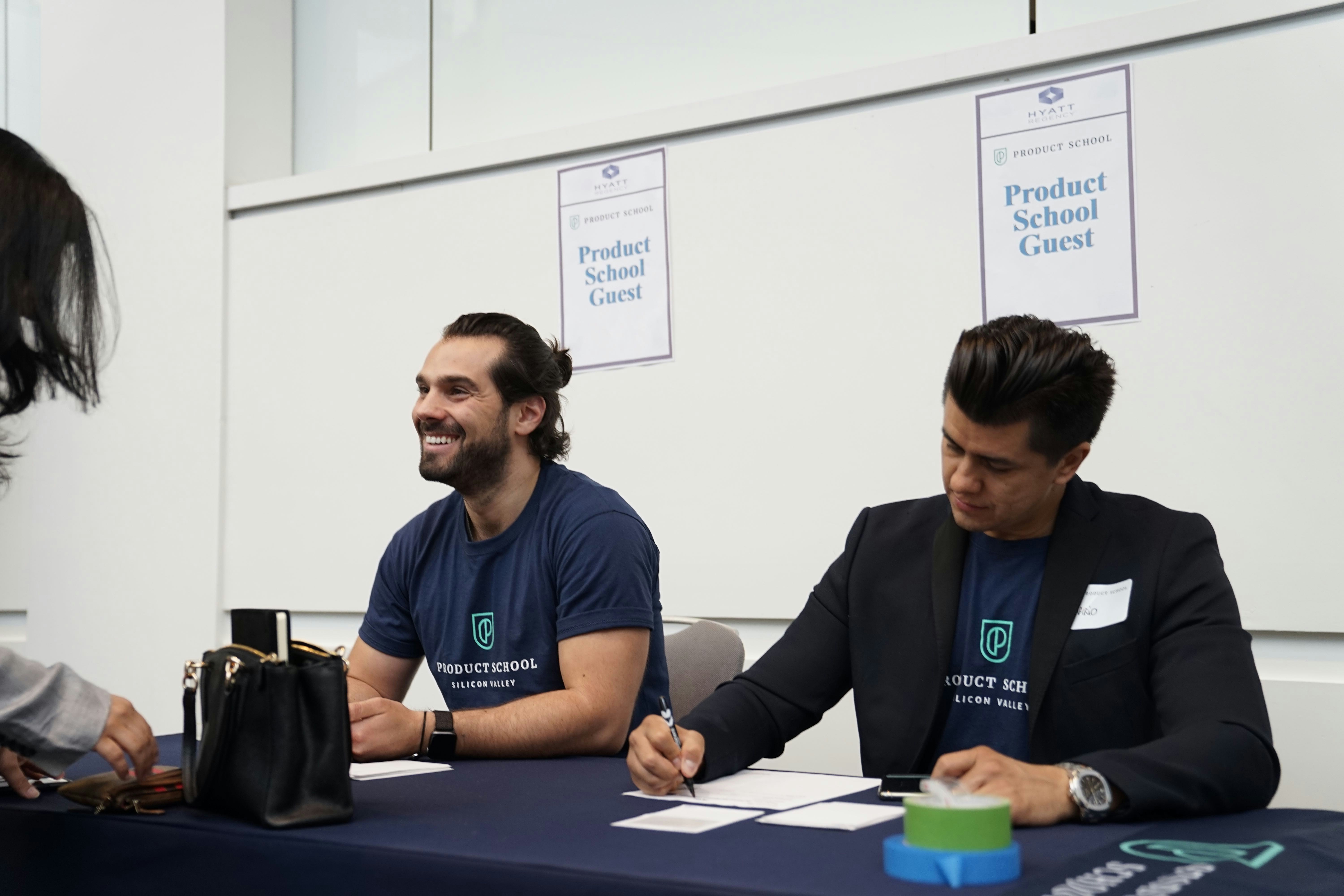 2 men checking in people for an event