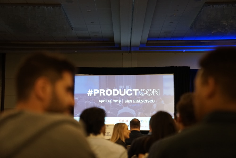 people in conference with projector screen in front