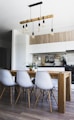 brown wooden dining table with white chairs near kitchen