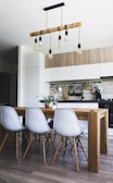 brown wooden dining table with white chairs near kitchen