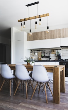 brown wooden dining table with white chairs in a kitchennear kitchen