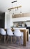 brown wooden dining table with white chairs near kitchen