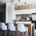 brown wooden dining table with white chairs near kitchen