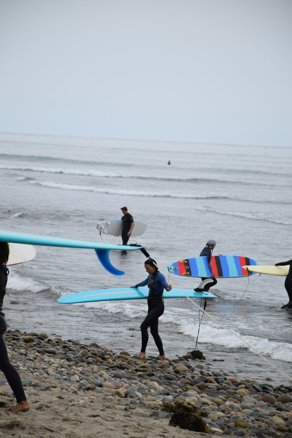 people holding surfboards in beach during daytime