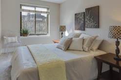 bed with comforter set beside table lamps on nightstands