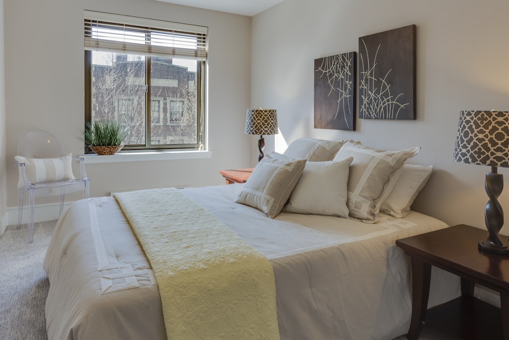 bed with comforter set beside table lamps on nightstands