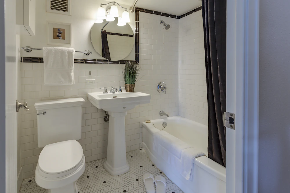 Bagno dai toni neutri con sanitario bianco e asciugamani ordinati