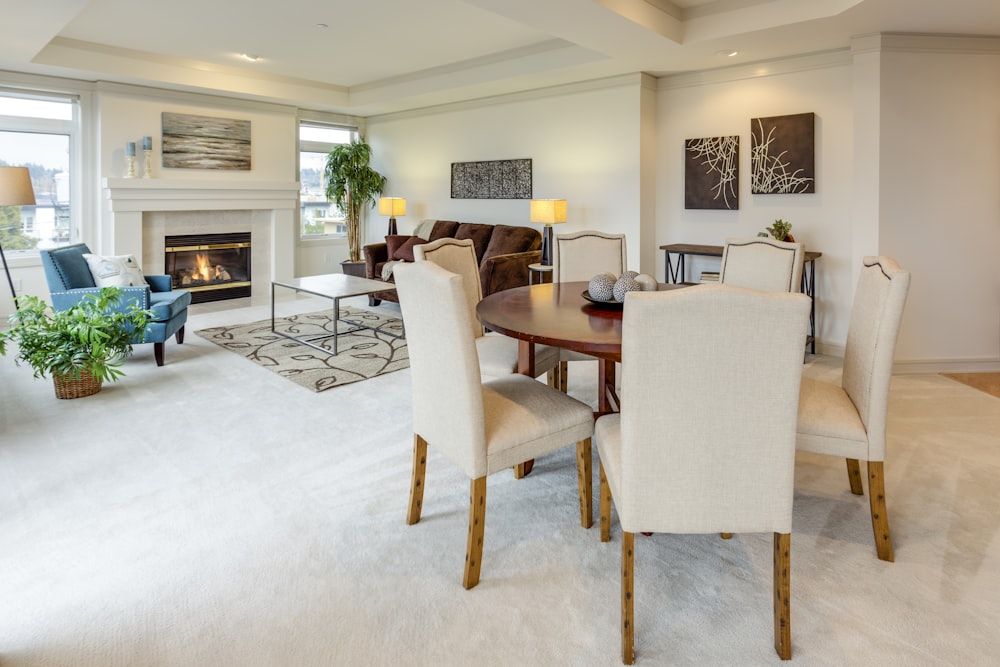 round brown wooden table with six white leather padded chairs