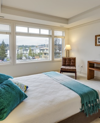 two green and white pillows on empty bed