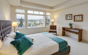 two green and white pillows on empty bed