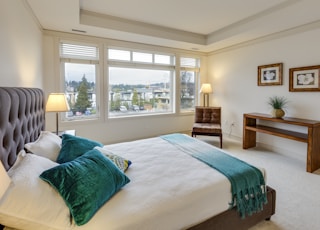 two green and white pillows on empty bed