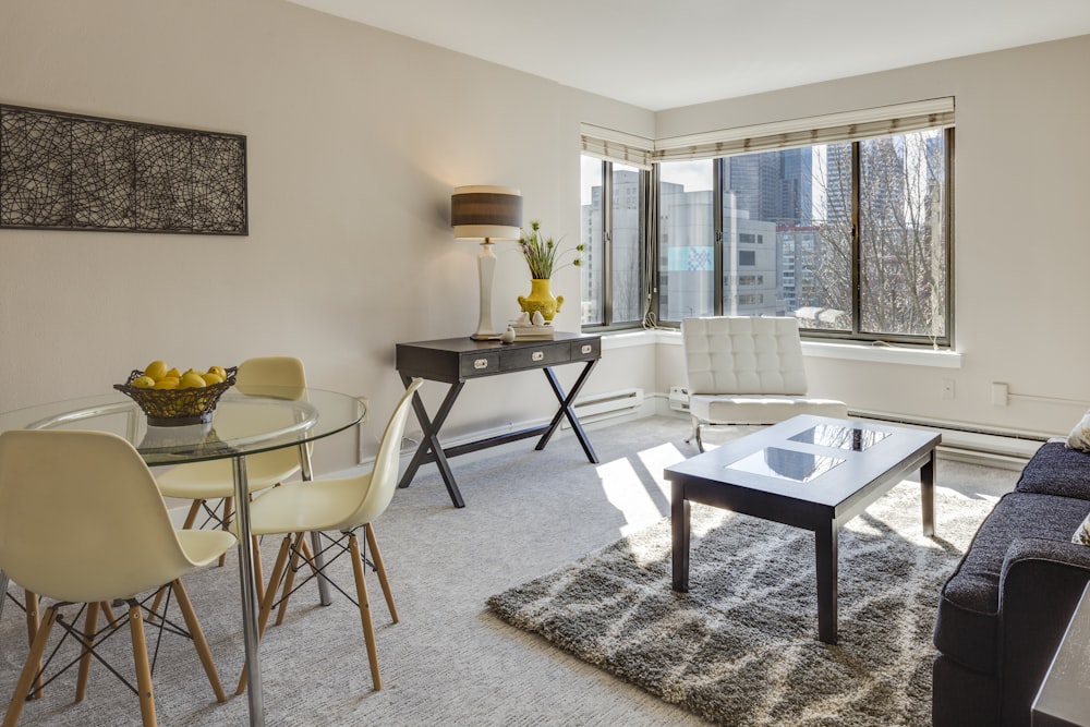 clear glass-top table and three chairs