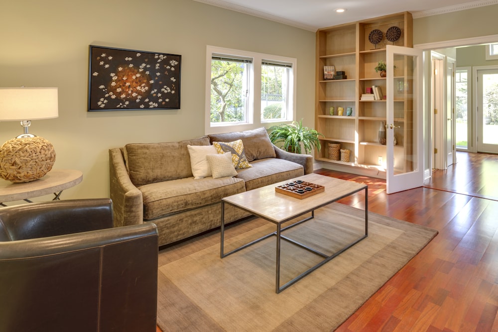 brown wooden table and couch with brown wooden bookshelf