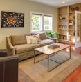 brown wooden table and couch with brown wooden bookshelf