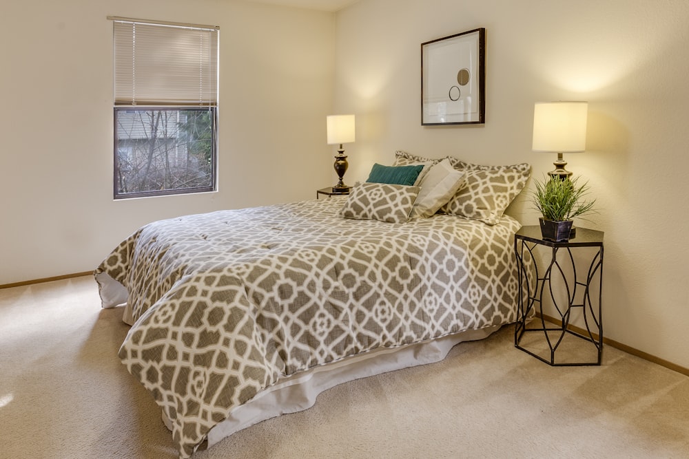 white-and-brown quatrefoil bedspread set on bed near window