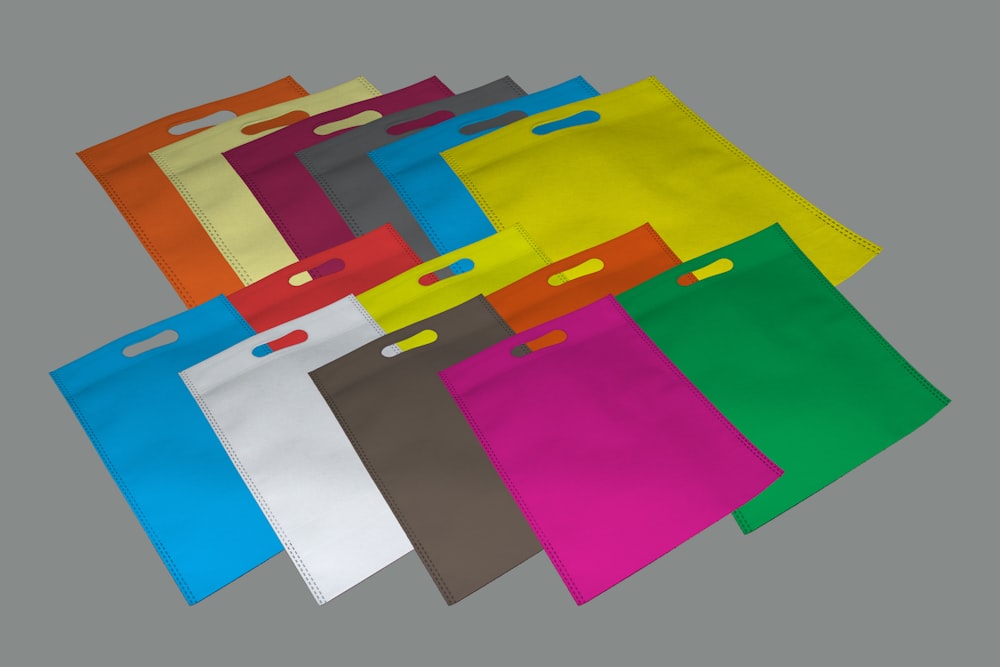 Bolsos de colores variados sobre superficie gris