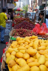 A vibrant market scene in Madagascar showing fresh lychees and spices being packed for export.