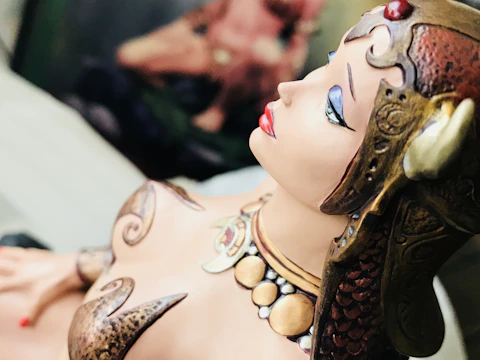 Close-up of a detailed 3D printed miniature figurine in burgundy tones.