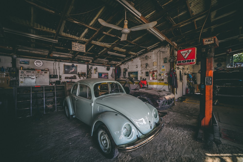 classic white Volkswagen Beetle coupe parked inside garage