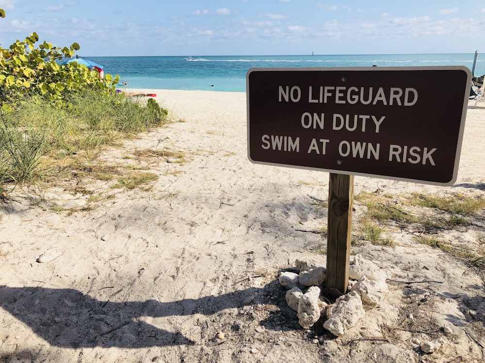 brown and white No lifeguard on duty signage