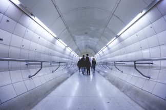 a group of people walking down a long hallway