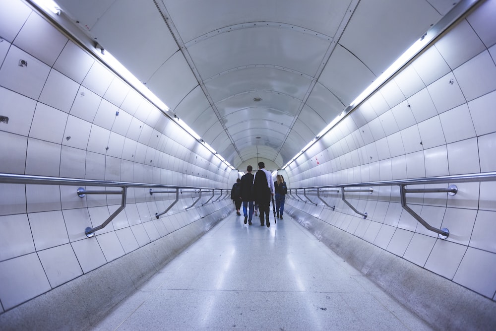 a group of people walking down a long hallway