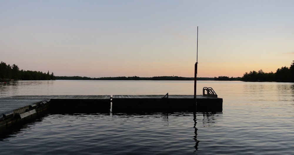 grey wooden dock on calm body of water