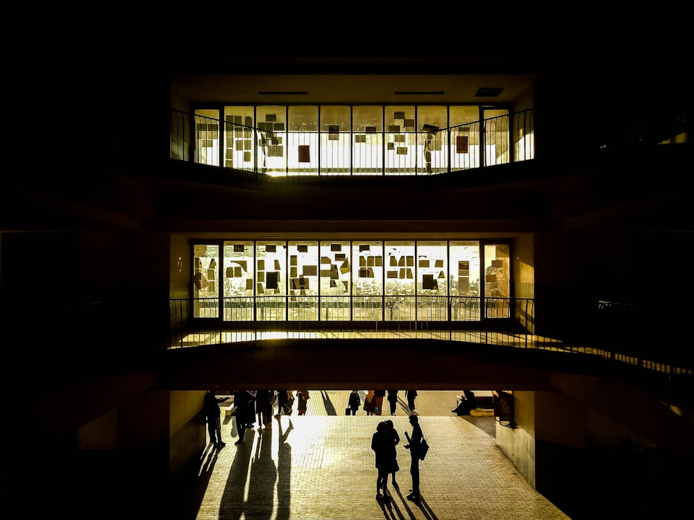 a group of people walking around a building at night