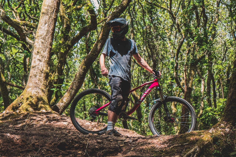 man holding red mountain bike