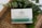 A product labeled 'Pharma Hemp Suppositories' is placed on a woven surface. The packaging details ingredients such as hemp cannabis extract, cocoa butter, coconut oil, and frankincense oil. Green foliage surrounds the product, enhancing a natural aesthetic.