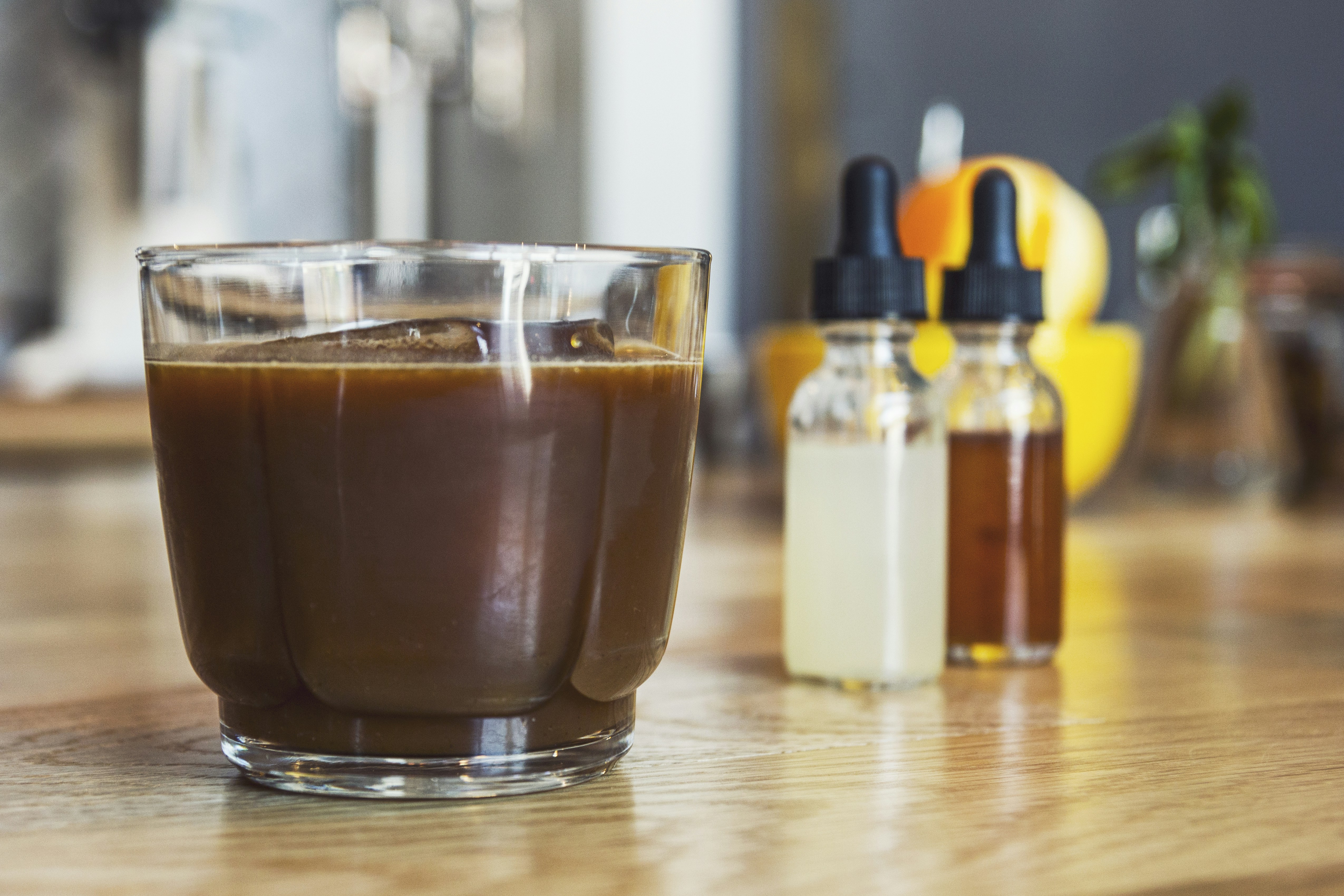 茶色の木製の表面に透明なガラスのコーヒー カップ