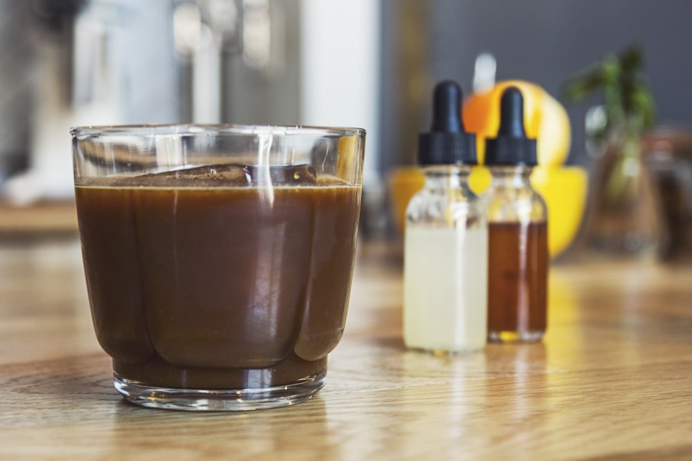 茶色の木製の表面に透明なガラスのコーヒー カップ